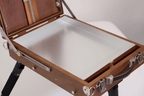 Wooden easel box opened with a metal palette on a white background