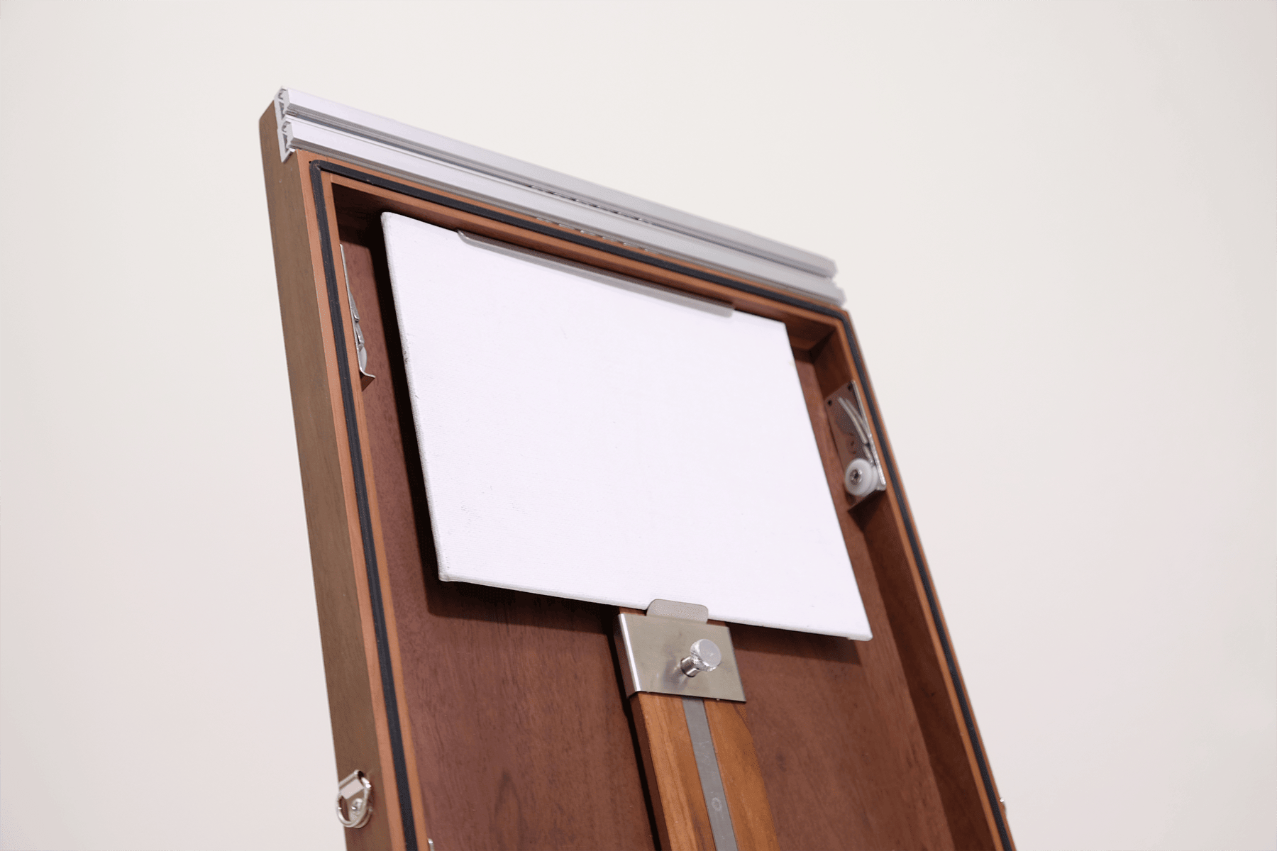 Wooden easel box with lid open with a white panel on a white background