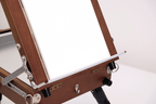 Wooden artist's easel with a white canvas on a white background
