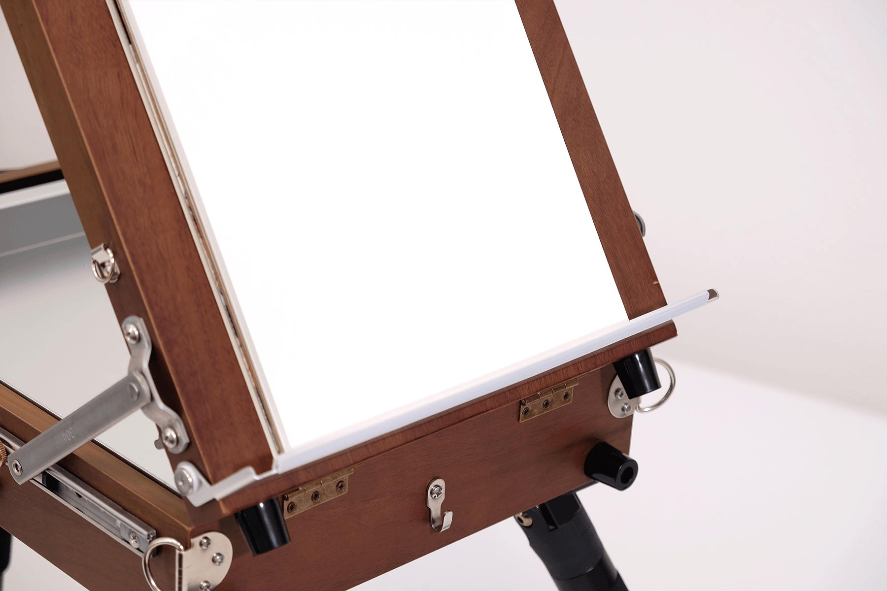 Wooden artist's easel with a white canvas on a white background